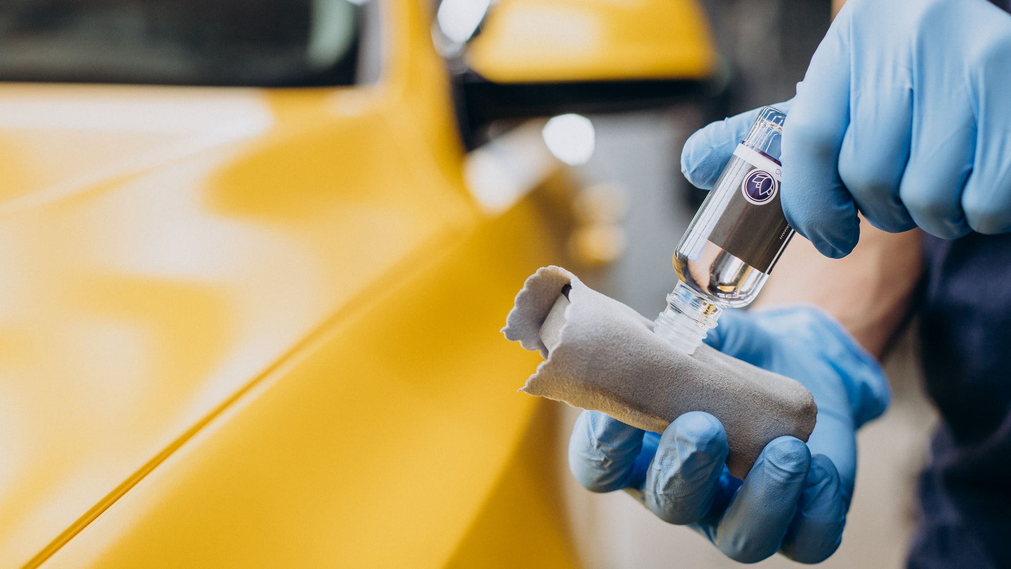 Man at car service doing car ceramic procedure